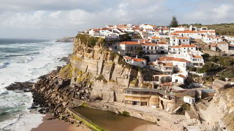 Postkort. Husklyngen Azenhas do Mar klynger seg fast i fjellsiden. Restaurante Da Adraga ligger helt nede ved stranden