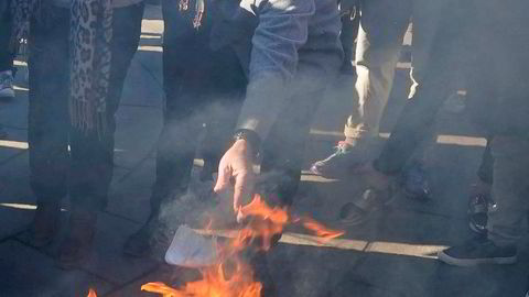 Svein Østvik (Charter-Svein) brenner munnbindet sitt under koronaskeptikernes markering utenfor Stortinget.