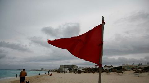 Det røde varselflagget er heist opp på en strand i Cancun i Mexico der orkanen Nate er forventet å treffe lørdag morgen meksikansk tid.