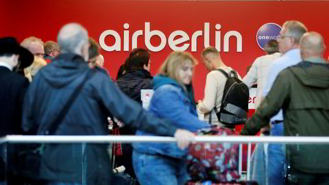 Reisende står i kø ved Air Berlins skranke på flyplassen i Düsseldorf etter at de møtte opp til en kansellert flyvning tirsdag.