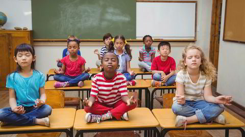 Amerikanske skole-elever mediterer i lotusstilling.
