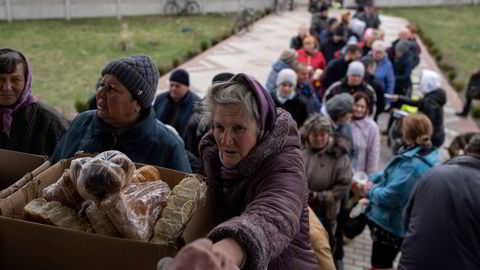 Ukrainske innbyggere mottar moat fra en kirke i Borodyanka, nordvest for hovedstaden Kyiv på søndag. Verdensbanken spår en full kollaps av økonomien – med store ringvirkninger til hele regionen.