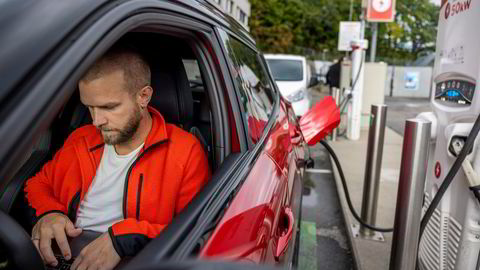 Lars Lillesveen lader elbilen sin på Circle K Skøyen. Han bruker ventetiden til å jobbe.