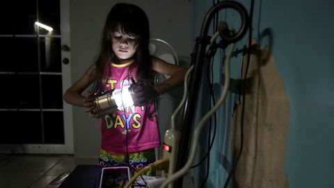 Seks år gamle Melanie Oliveras Gonzalez holder en lanterne inne i stuen der hun og familien bor i Morovis i Puerto Rico. Halvparten av landets strømkunder er fortsatt uten strøm, tre måneder etter at orkanen Maria traff øya.
