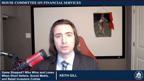 Keith Gill deltar i videohøringen fra hjemmet sitt. I bakgrunnen skimtes et lerret med et bilde av en katt på – en referanse til at Gill kaller seg «Roaring Kitty» på Youtube, hvor han blant annet snakker om sine finansielle investeringer.