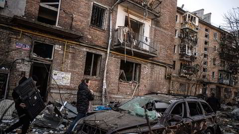 Et kjærestepar – beboere i et leilighetskompleks i Kyiv som ble ødelagt av en bombe morgenen 18. mars – bærer ut eiendeler de klarte å redde fra ruinene av leiligheten, blant annet en tv.
