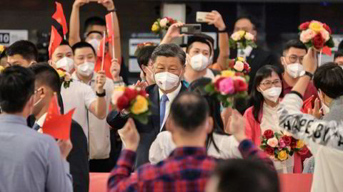 Kinas Xi Jinping vinket til en liten gruppe som fikk møte opp da han ankom West Kowloon jernbanestasjon i Hongkong fra det kinesiske fastlandet. Hongkong markerer på fredag 25 år siden tilbakeføringen av den tidligere britiske kronkolonien til Kina.