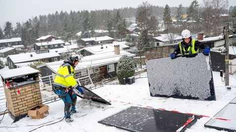 Montørene Roy Karlsson og Rune Kiil (til høyre) trosser snøvær for å montere Bjørn Evensens solceller. – Alle som har litt til overs bør vurdere å investere i solceller eller varmepumpe, mener den kommende solcelle-eieren.