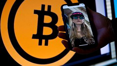 Heather Morgan, pictured on a phone in front of the bitcoin logo, was arrested and charged with attempting to launder more than $3.6bn in stolen bitcoin with her husband, Ilya Lichtenstein.