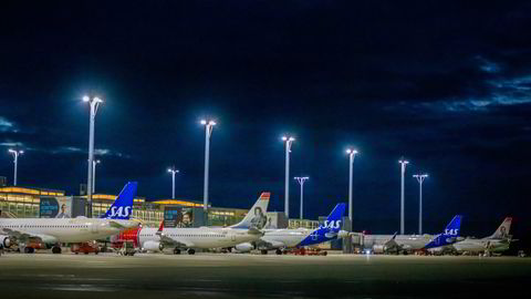 SAS-fly parkert ved gaten på Oslo lufthavn Gardermoen ved siden av konkurrenten Norwegian.