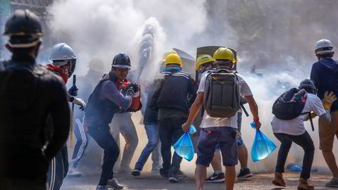 Demonstranter bruker brannslukningsapparater for å beskytte seg mot tåregass i Yangon i mars i år. Protestene var svar på kuppet i februar.