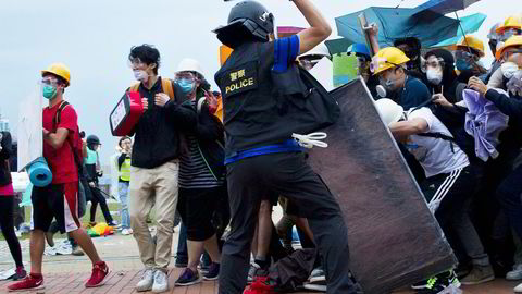 Politi og demonstranter støter sammen i Hong Kong den 1. desember. Men etter to måneders kamp oppfordrer nå lederne for Occupy Central demonstrantene til å gi opp. Foto: Dale de la Rey, AFP/NTB Scanpix