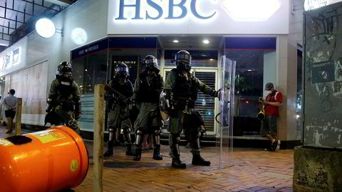 Lokalt opprørspoliti står utenfor en HSBC-filial i nabolaget Wan Chai i Hong Kong tidligere denne måneden.
