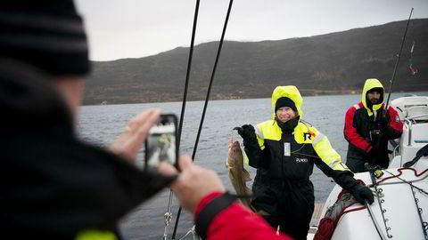 Steve Brown fra Texas tar bilde av kona Laura Brown, som akkurat har halt opp en torsk fra en av Pukka Travels seilkatamaraner i Kvalsundet nord for Tromsø. Turist Jose Galdon (til høyre) fikk ingen fisk.
