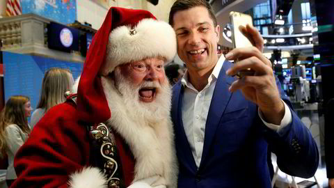 Toppsjef for New York-børsen, Tom Farley, poserer for en selfie med varehuset Macy's' julenisse.  Julenissen fikk æren av å ringe åpningsklokken da børsen åpnet Thanksgiving-helgen onsdag.