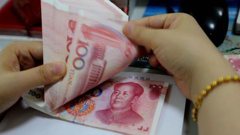 En bankansatt teller kinesiske Yuan-sedler i en filial i Lianyungang i Jiangsu-provinsen. Foto: China out/AFP photo/NTB scanpix