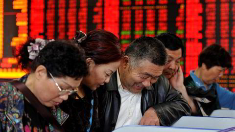 KINA: Investorer sjekker aksjekurser hos et meglerhus i Fuyang i Anhui-provinsen. Foto: China Daily/Reuters/NTB scanpix