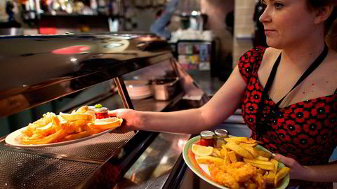 Fredag trer en ny lov i kraft i Storbritannia som setter minimumslønnen til 7,20 pund i timen. Her leverer en servitør i Øst-London ut fish and chips. Foto: AFP/Leon Neal/NTB Scanpix