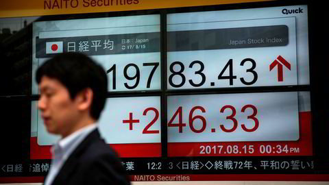 En skjerm i Tokyo viser utviklingen i Nikkei-indeksen tidligere på dagen tirsdag. Det er tegn til lettelse i asiatiske markeder etter uttalelser fra Nord-Koreas leder om at han vil vente med et eventuelt angrep på den amerikanske stillehavsøyen Guam.