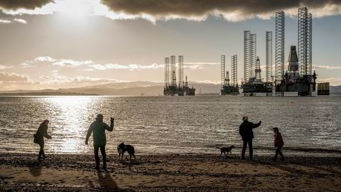 Flere rigger ligger i opplag i bakgrunnen, men folk som bor her I Cromarty i Skottland er vant til dem. Beti Bricelj, Mike Schroeder og Leon Patchett, går tur langs stranden.