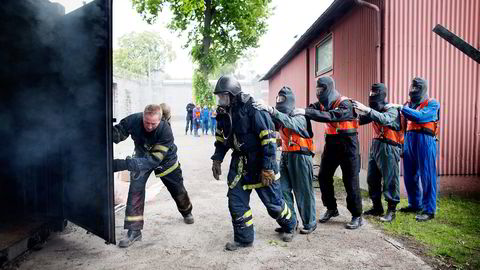 Instruktør Arve Martinsen sender de kommende sommervikarene inn i en røykfylt container. De skal få kjenne på følelsen av å være fanget i et rom med brann og røyk. Foto: