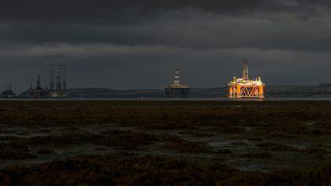 En stripe sol lyser opp en av de ti oljeriggene som ligger i opplag i Cromarty Firth, en fjord på den skotske østkysten