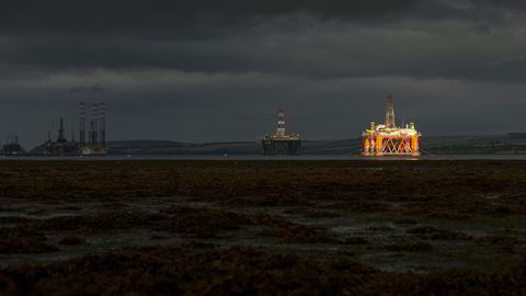 En stripe sol lyser opp en av de ti oljeriggene som ligger i opplag i Cromarty Firth, en fjord på den skotske østkysten