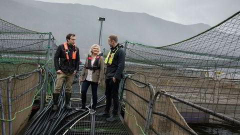 Randi Herre Eide og sønnene Erlend (til venstre) og Sondre står ute i smoltanlegget i Skogseidvatnet like ved bedriftens hovedkvarter i Fusa kommune.