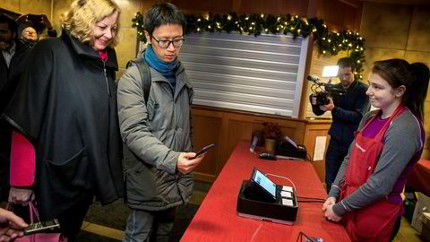 Vipps' internasjonale direktør Berit Svendsen følger med når forretningsutvikler Ruimin Yang demonstrerer mobilbetaling i kassen – delvis ved hjelp av Vipps' teknologi og infrastruktur. Vertinne Helene Karlsen i Pepperkakebyen i Bergen får bekreftet betalingen nesten umiddelbart.