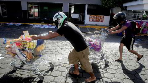 Motstand mot en pensjonreform har ført til store protester i Nicaraguas hovedstad, Managua. Bildet viser personer som har plyndret en butikk etter gateprotester.