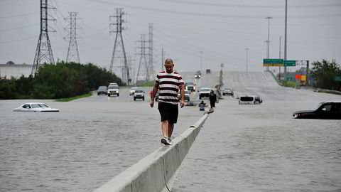 En mann måtte forlate bilen sin på en av motorveiene inn til Houston, Texas. Vannmengdene lammet store deler av storbyen mandag.