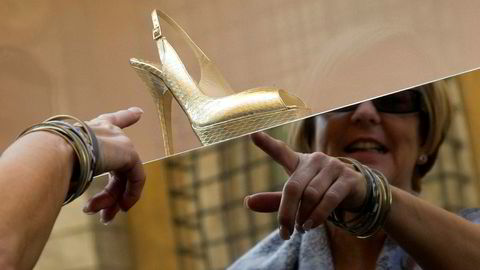 En kvinne betrakter en Jimmy Choo – sko i et utstillingsvindu på Via Condotti i Roma.