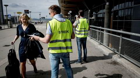 Streikevaktene Runar Østby (i midten) og Øystein Syrist (til høyre) deler ut løpesedler ved Oslo lufthavn Gardermoen tirsdag. Ingen av pilotene ville snakke med mediene.