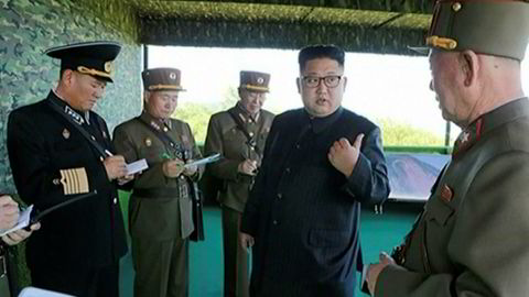 Nord-Koreas diktator, Kim Jong-un poserer sammen med militære. Han har bidratt til å øke spenningen betraktelig med en ny rakett som passerte over Japan.