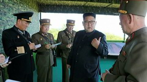 Nord-Koreas diktator, Kim Jong-un poserer sammen med militære. Han har bidratt til å øke spenningen betraktelig med en ny rakett som passerte over Japan.