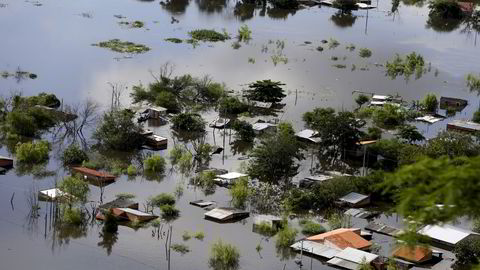 Flere hus er dekket av vann i Paraguays hovedstad Asunción. Mange mennesker må flykte fra hjemmene sine på grunn av flom og oversvømmelser. Foto: Jorge Adorno / Reuters / NTB scanpix