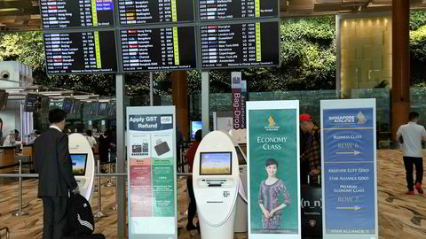 En Singapore Airlines-passasjer sjekker inn ved de automatiske innsjekkingsboksene på utenlandsterminalen ved Changi-flyplassen i Singapore torsdag 11. oktober.