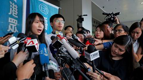 De to pro-demokrati-aktivistene Agnes Chow og Joshua Wong møtte mediene etter å ha blitt løslatt mot kausjon fredag ettermiddag i Hongkong. – Vi vil fortsette denne kampen selv om de fortsetter å arrestere og tiltale oss, sa Wong.