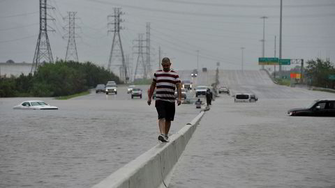 En mann balanserer mens han går langs motorveien Interstate 225 etter at orkanen Harvey rammet Texas. Det kan komme mer ekstremvær til USA om ikke lenge.