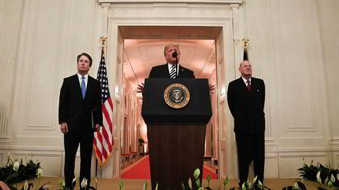 Brett Kavanaugh (til venstre) og pensjonert høyesterettsdommer Anthony Kennedy (til høyre) hører på Donald Trumps tale under seremonien i Det hvite hus mandag.