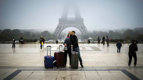 Turister i Paris tar en selfie med Eiffeltårnet i bakgrunnen.