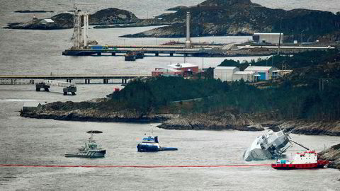 Den norske fregatten "KNM Helge Ingstad" ligger med slagside nær land etter at den kolliderte med tankskipet "Sola TS" natt til torsdag. Deler av Stureterminalen i bakgrunnen.