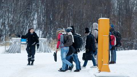 En politikvinne viser en gruppe asylsøkere videre på Storskog grenstasjon i Finmark. Foto: Cornelius Poppe,
