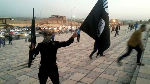FILE PHOTO: A fighter of the Islamic State of Iraq and the Levant (ISIL) holds an ISIL flag and a weapon on a street in the city of Mosul June 23, 2014. REUTERS/Stringer/File Photo