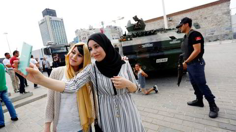 Det mislykkede militærkuppet har gjort Tyrkia-ferien enda billigere for turistene. Her tar to turister fra Algerie bilde foran en forlatt tanks. Foto: Murad Sezer/Reuters/NTB Scanpix