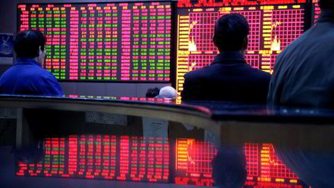Investorer sjekker aksjekurser på elektroniske tavler hos et meglerhus i Shanghai. Foto: