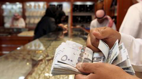 En butikkselger teller penger i en juveler på gullmarkedet i Riyadh i Saudi-Arabia. Foto: