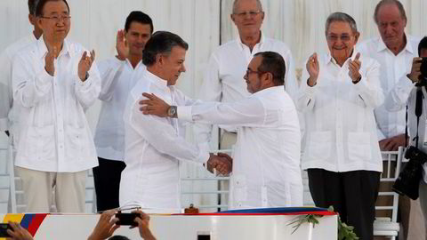 Colombias president Juan Manuel Santos (venstre) og FARC-leder Rodrigo Londoño, også kjent som Timoleón Jiménez og Timochenko, tar hverandre i hånden etter å signert fredsavtalen som avslutter en over 50 år lang krig som har kostet rundt 250.000 personer livet. Foto: John Vizcaino /Reuters/NTB scanpix