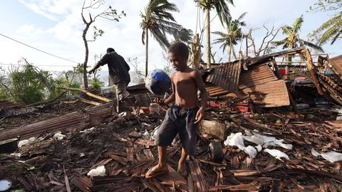 Gutten som bare oppgir fornavnet sitt Sam, bærer en ball gjennom ruinene av det som var et hjem i Port Vila på Vanuatu. Syklonen Pam herjet øystaten i helgen. Foto: AP Photo/Dave Hunt, NTB Scanpix.