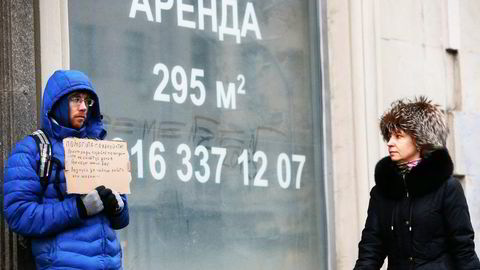 Russere opplever økonomisk krise og kollaps i eiendomsmarkedet. En tigger foran tomme butikklokaler til leie i Moskva. Foto: Sergej Karpukhi, Reuters/NTB Scanpix